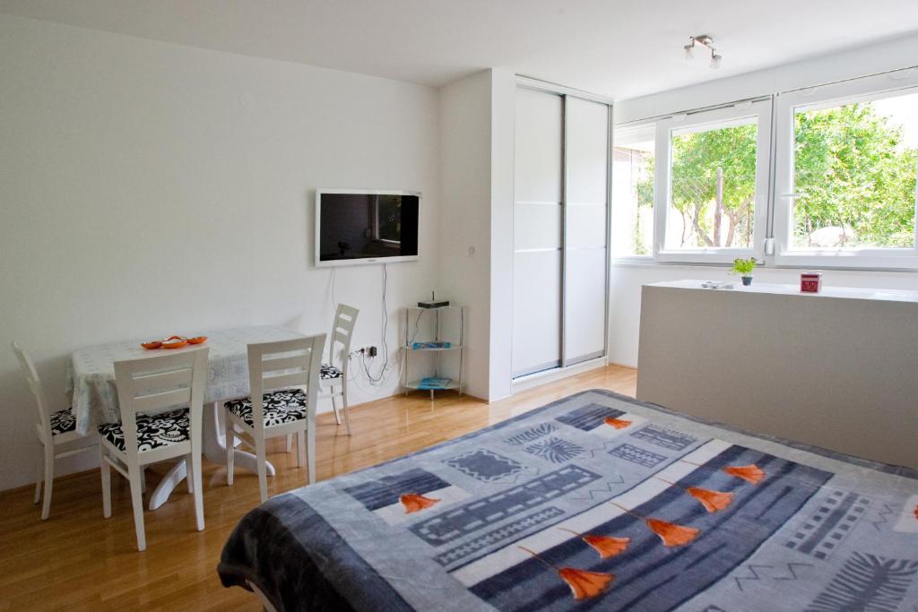 Zimmer mit einem Bett und einem Tisch mit Stühlen in der Unterkunft Apartment Busic in Split in Split