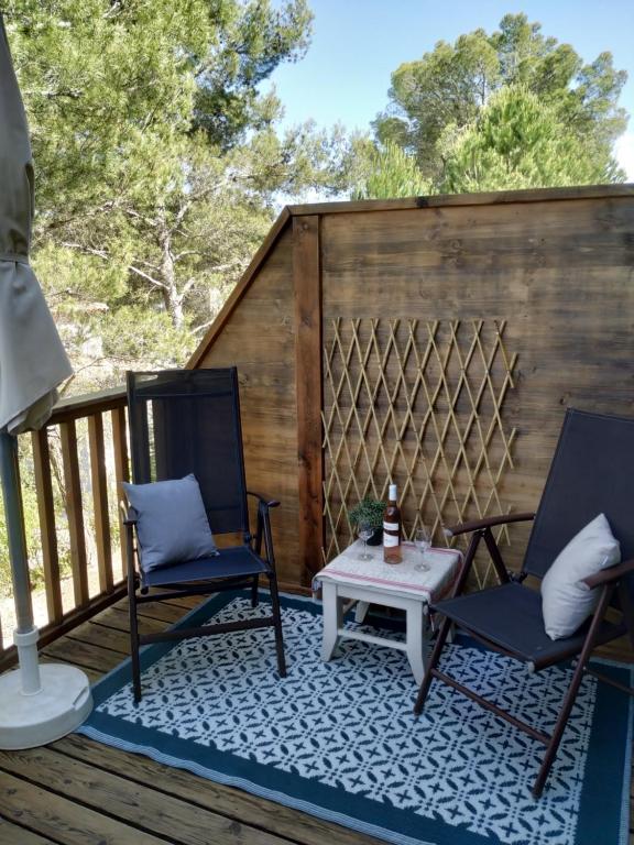 un patio avec deux chaises et une table sur une terrasse dans l'établissement Les Coteaux B10, à Mallemort