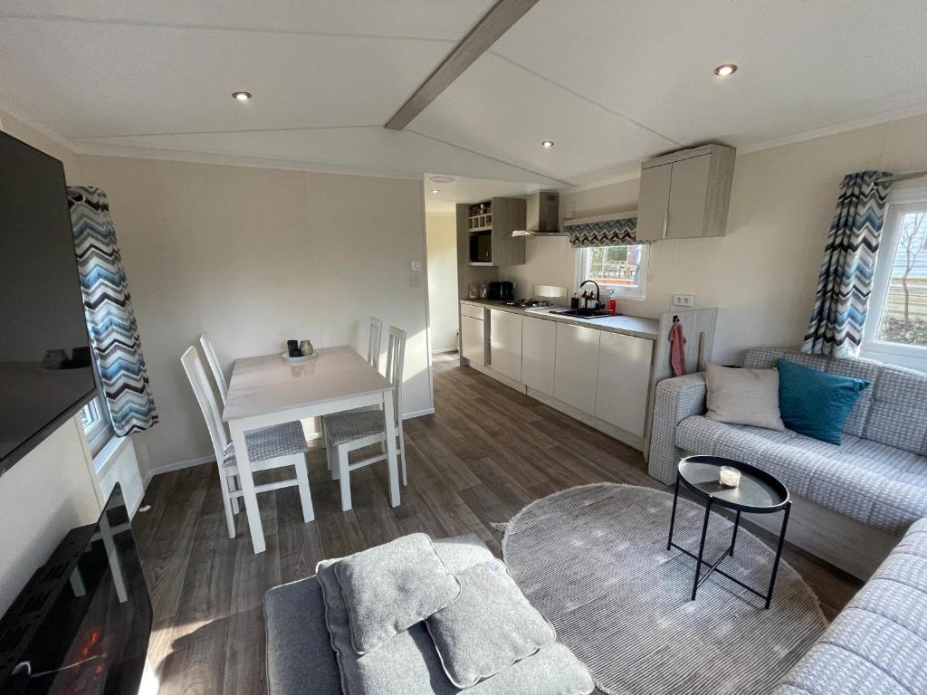 een woonkamer met een bank en een tafel bij Luxe Chalet Hoenderloo Airco, Netflix - Recreation Only in Hoenderloo