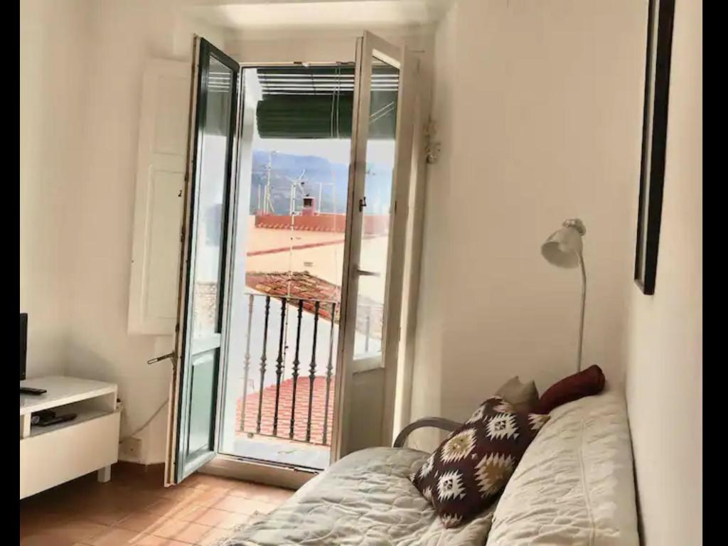 a room with a bed and a view of a balcony at Apartamento luminoso y acogedor Port de la Selva in Port de la Selva