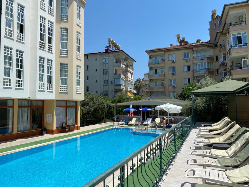 uma piscina com espreguiçadeiras junto aos edifícios em İSABELLA APART OTEL em Alanya