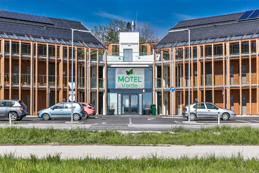 un edificio con coches estacionados en un estacionamiento en Motel Verde en Schönau an der Triesting