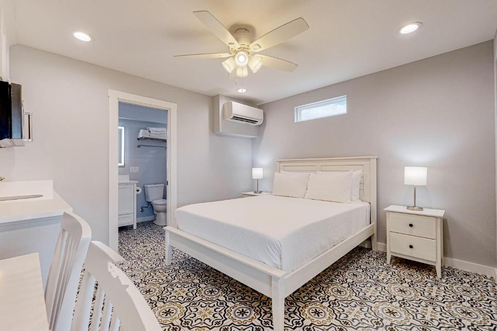 a bedroom with a white bed and a ceiling fan at Sweet Studio Suite in Rockport