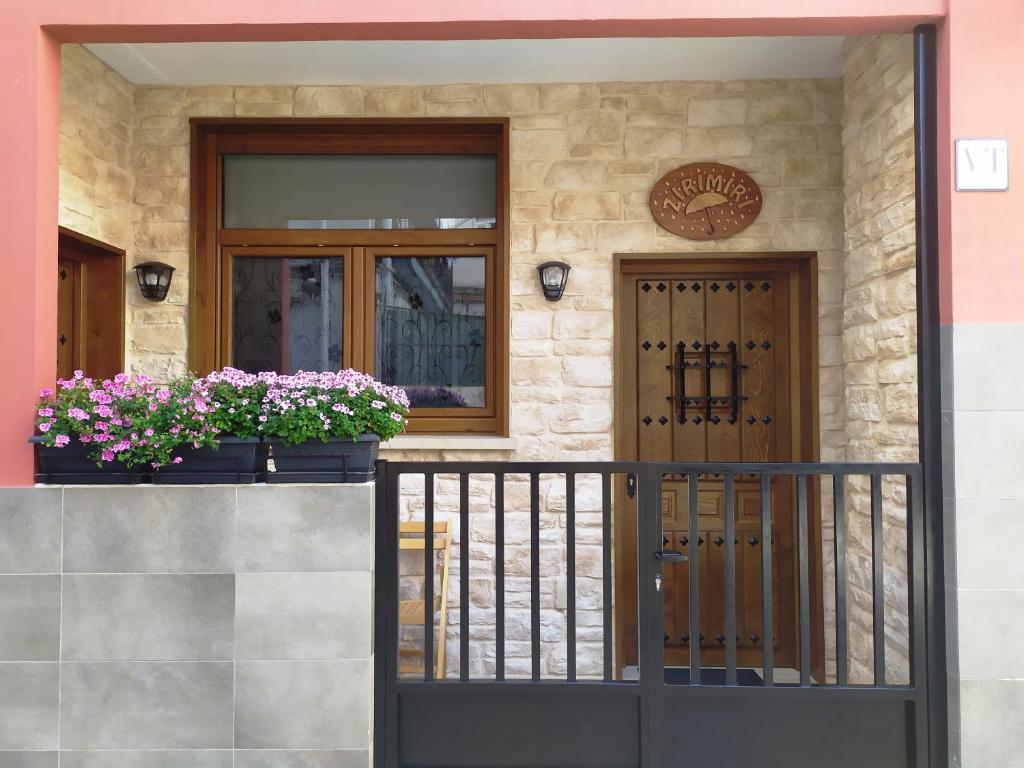 eine Eingangstür eines Hauses mit zwei Topfpflanzen in der Unterkunft Apartamento con encanto "ZIRIMIRI" in Bermeo