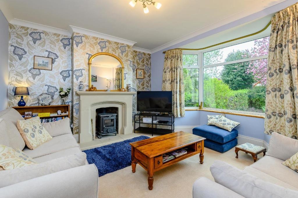 a living room with a fireplace and a tv at Caradoc in Chepstow