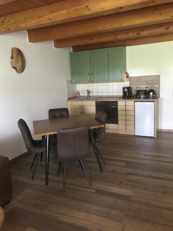 a kitchen with a table and chairs in a room at Apartment Sioux in Eging