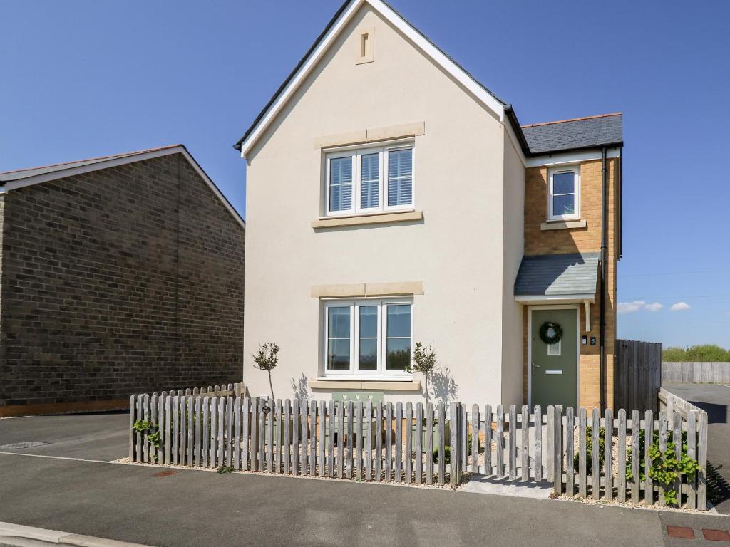 a house with a white picket fence at 5 Ffordd Y Meillion in Llanelli