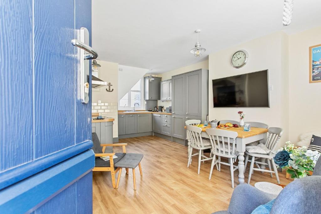 een keuken en eetkamer met een tafel en stoelen bij Captains Cottage - Stylish cottage, level location, in the heart of Dartmouth in Dartmouth
