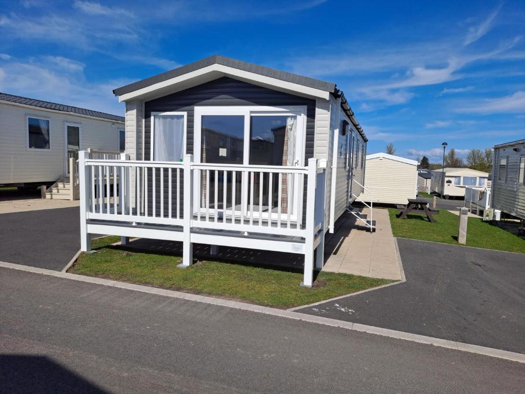 a tiny house in a parking lot with a porch at Edwards Holiday Home in Blackpool