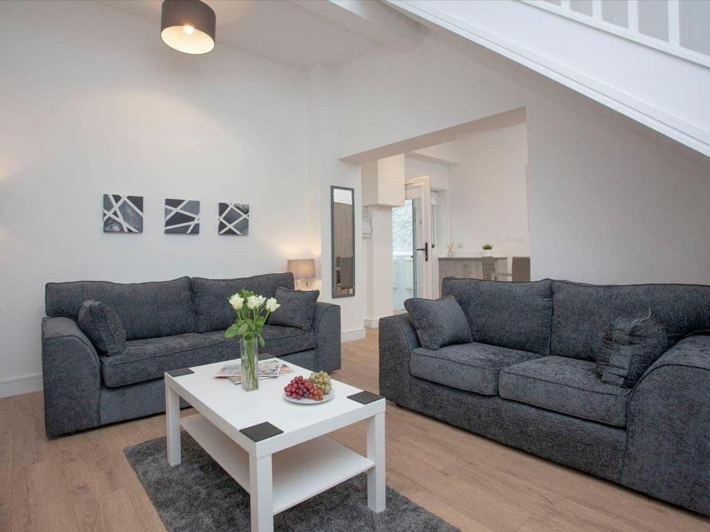 a living room with two couches and a table at 1 primrose mews in Torquay