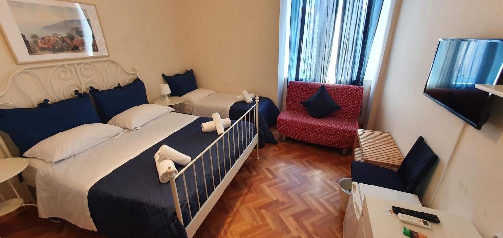 拿坡里的住宿－Napol-In，一间小卧室,配有两张床和红色椅子