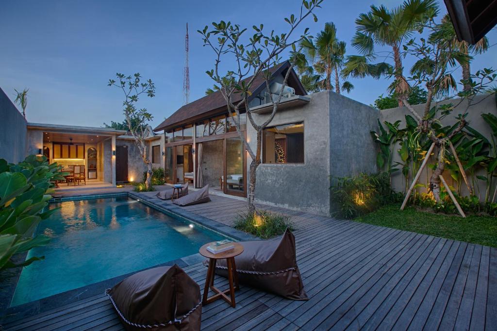 uma casa com piscina em frente a uma casa em Taman Dharmawangsa Suites em Nusa Dua