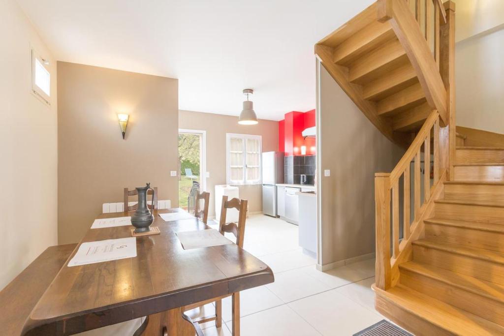 une salle à manger avec une table en bois et un escalier dans l'établissement Maison Baduel, à Auxey-Duresses