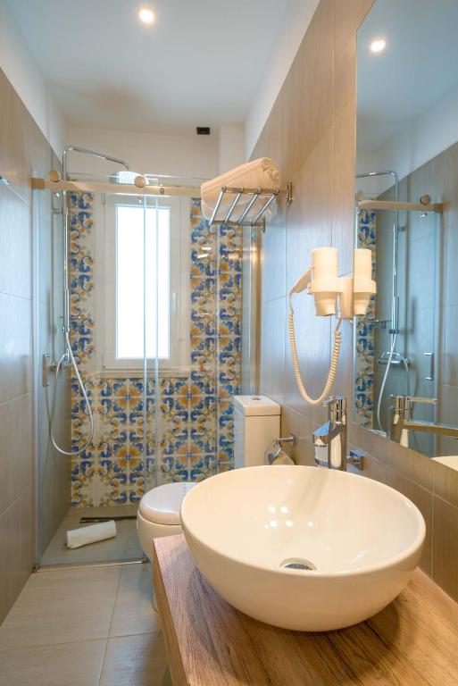 a bathroom with a white sink and a toilet at Hotel Rivage Taormina in Taormina
