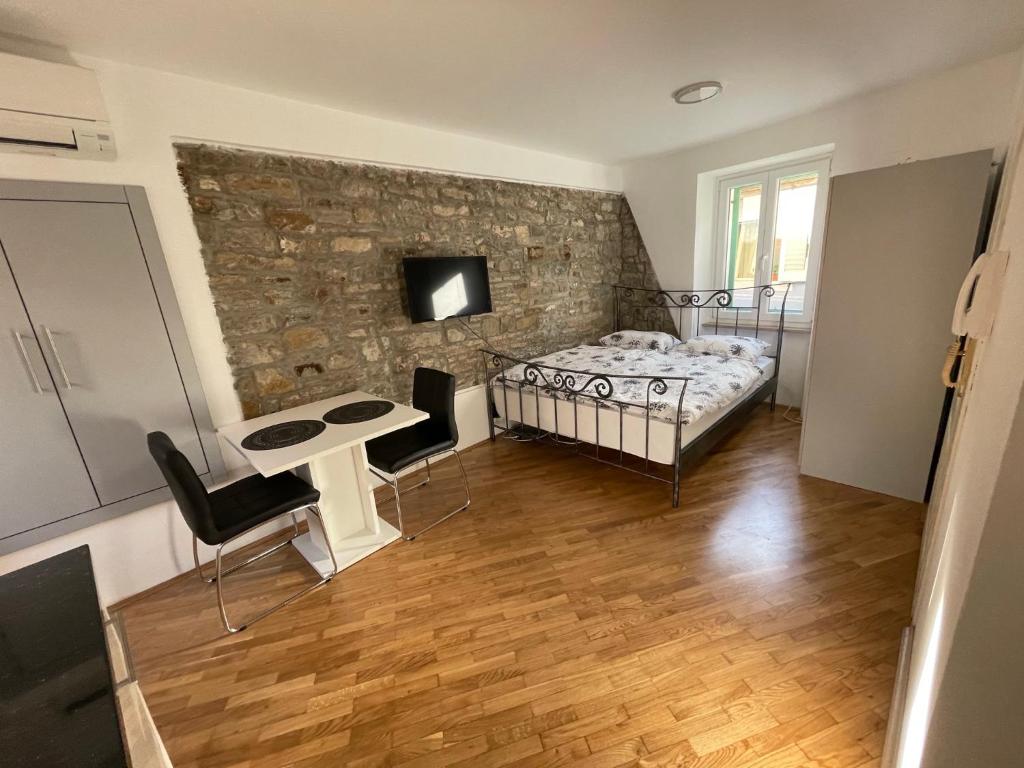 1 dormitorio con cama y pared de piedra en Casa David en Piran