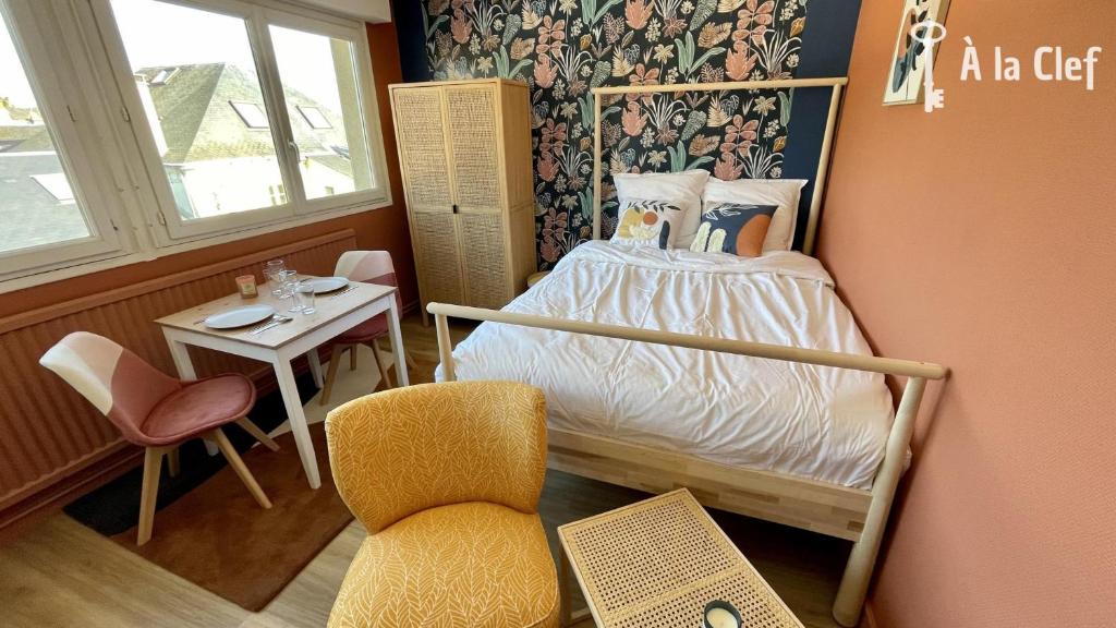 a small bedroom with a bed and a chair at A la Clef - Studio Terre de feu proche gare et centre in Le Mans