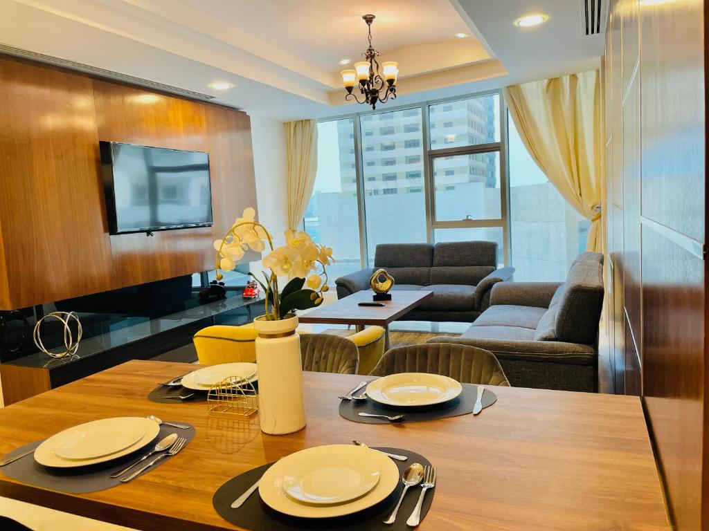 a dining room and living room with a dining table at Kiev Tower Hotel Apartments in Manama