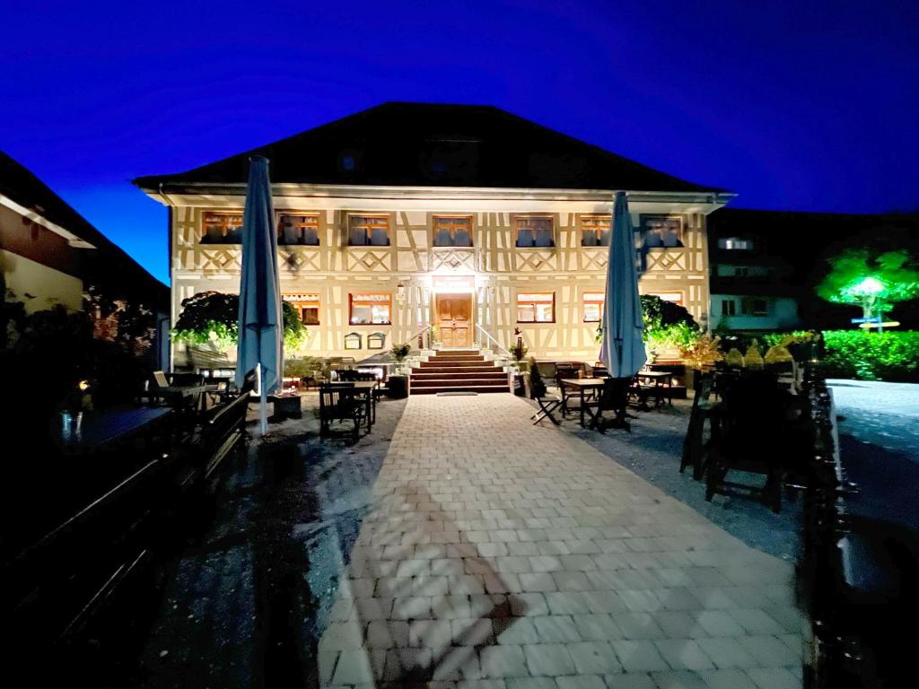 a building with blue umbrellas and tables and chairs at Hotel Adler Ittendorf in Ittendorf