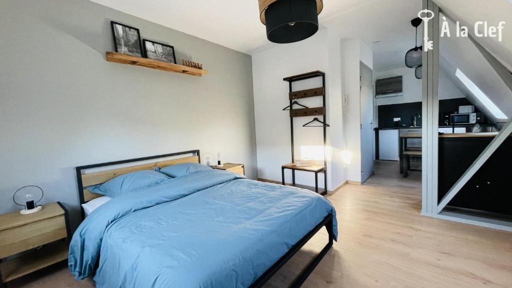 - une chambre avec un lit bleu et un escalier dans l'établissement A la Clef - Charmant studio proche gare et centre - Idéal PRO & Couple - WIFI, au Mans