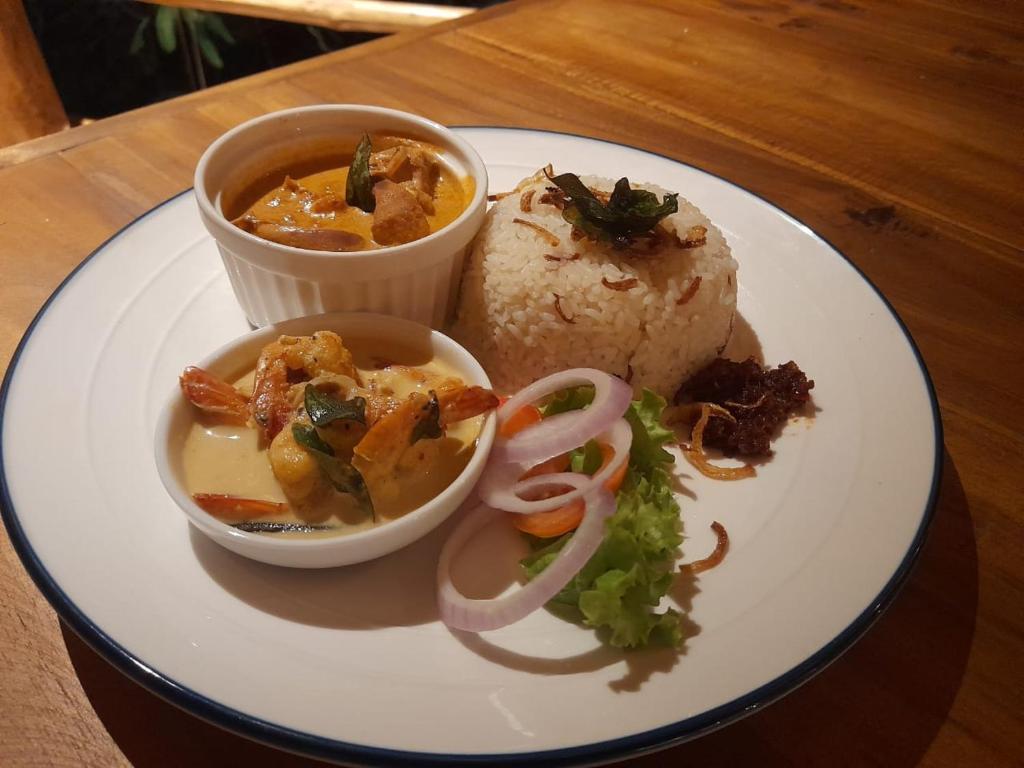 a plate of food with a bowl of soup and rice at Oruwa Boutique Villas in Arugam Bay
