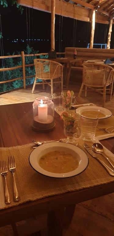 a table with a plate of soup and a candle at Oruwa Boutique Villas in Arugam Bay