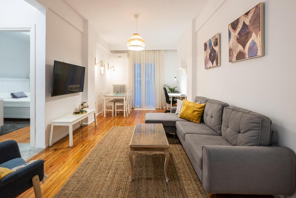 uma sala de estar com um sofá e uma mesa em Ikos central spacious apartment em Tessalônica