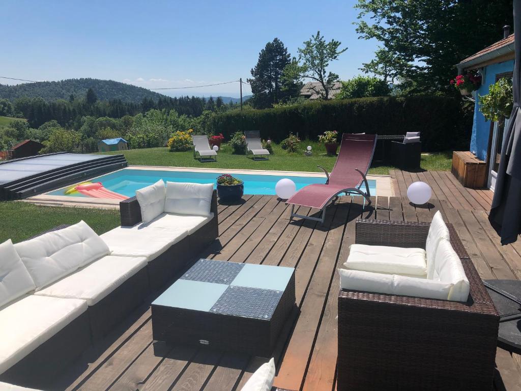 a patio with a couch and chairs and a pool at La maison bleue in Altenbach