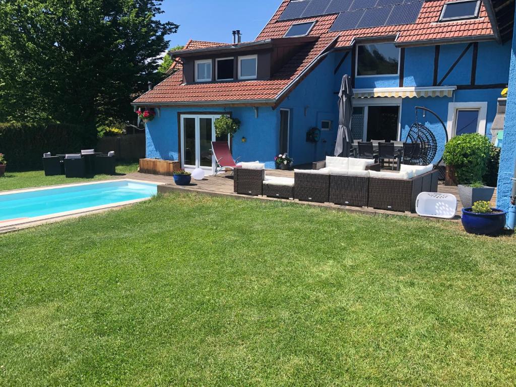 a blue house with a swimming pool in a yard at La maison bleue in Altenbach