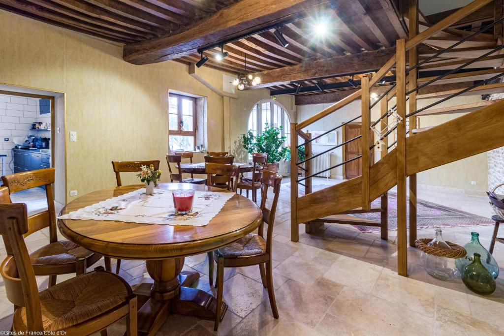 - une salle à manger avec une table et des chaises en bois dans l'établissement Les Vendangettes, à Gevrey-Chambertin