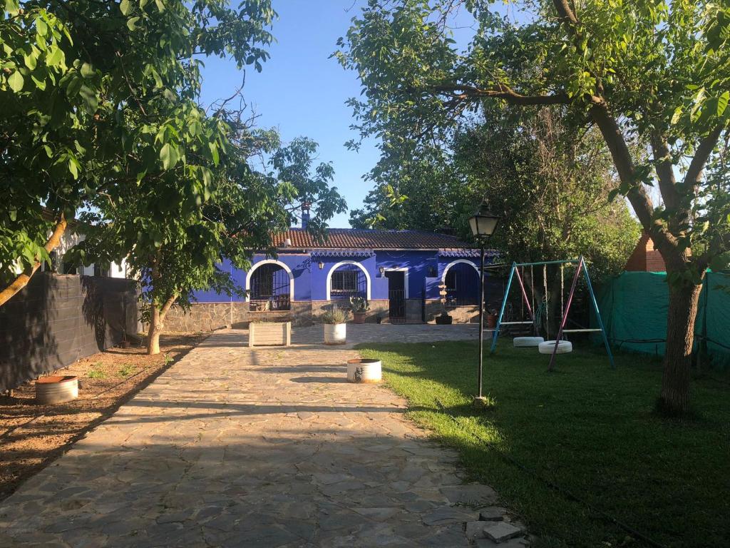une maison bleue avec une aire de jeux dans une cour dans l'établissement Casa De Campo Azul En Antequera, à Antequera
