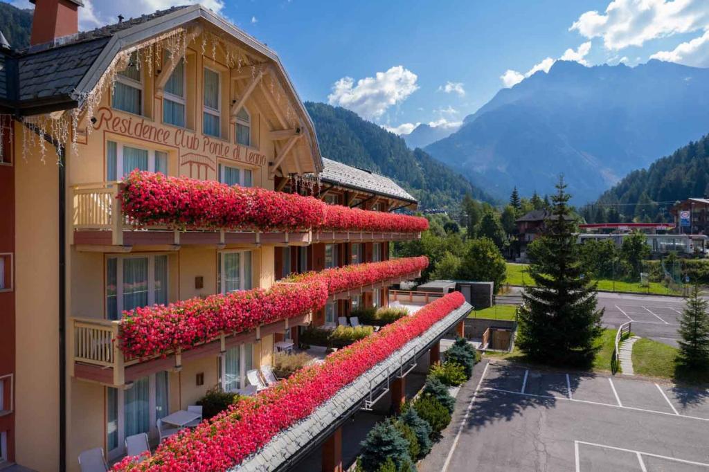 a building with flowers on the side of it at Residence Club Ponte Di Legno in Ponte di Legno