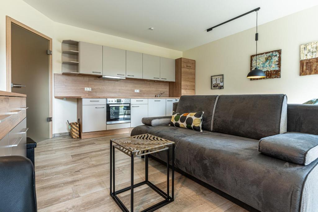 ein Wohnzimmer mit einem Sofa und einem Tisch in der Unterkunft Strandresidenz Dünenperle, App 6 in Kühlungsborn