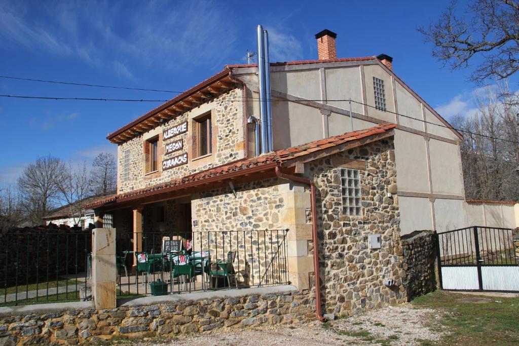 una vieja casa de piedra con una valla alrededor en Hostel Curavacas, en Triollo
