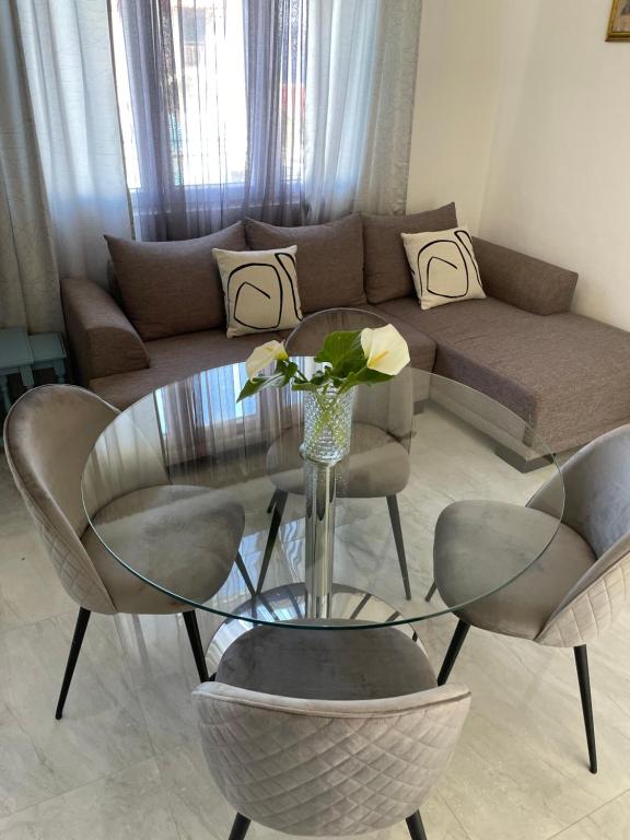 ein Wohnzimmer mit einem Glastisch und Stühlen in der Unterkunft Apartman Luš in Sutivan