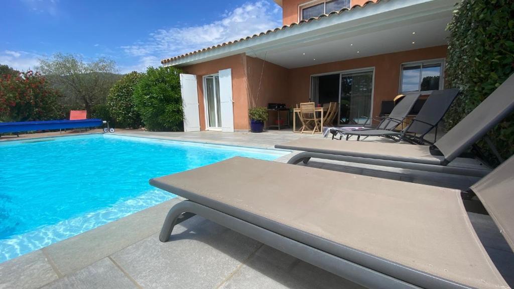 - une piscine avec une table et une maison dans l'établissement Maison porto vecchio - lecci, à Porto-Vecchio