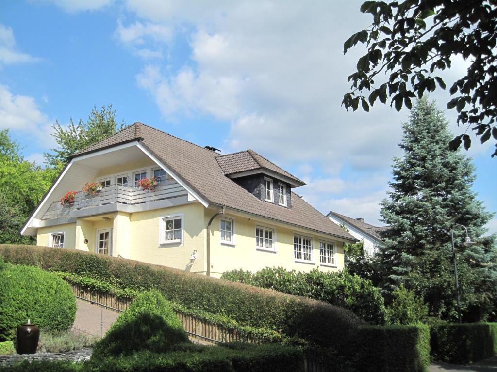 a yellow house with flowers on the balcony at Apartment Lieserpfad-Wittlich in Wittlich