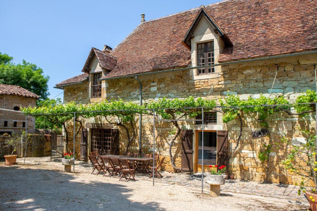 un antico edificio in pietra con tavolo e sedie di Château de Béduer and Vacation Homes a Béduer