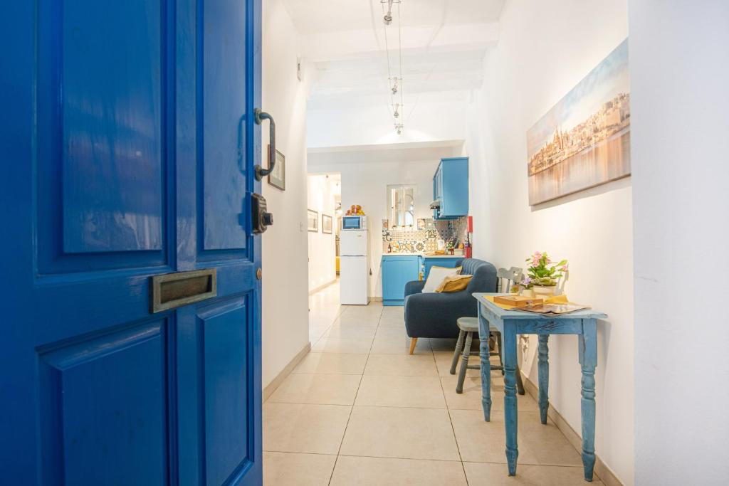 Una puerta azul que da a una sala de estar con mesa. en Valletta Ferry Apartment en La Valeta