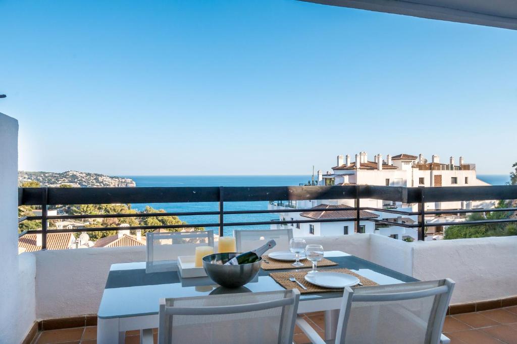 une table et des chaises sur un balcon avec vue sur l'océan dans l'établissement Carmen de la Bahía, à La Herradura