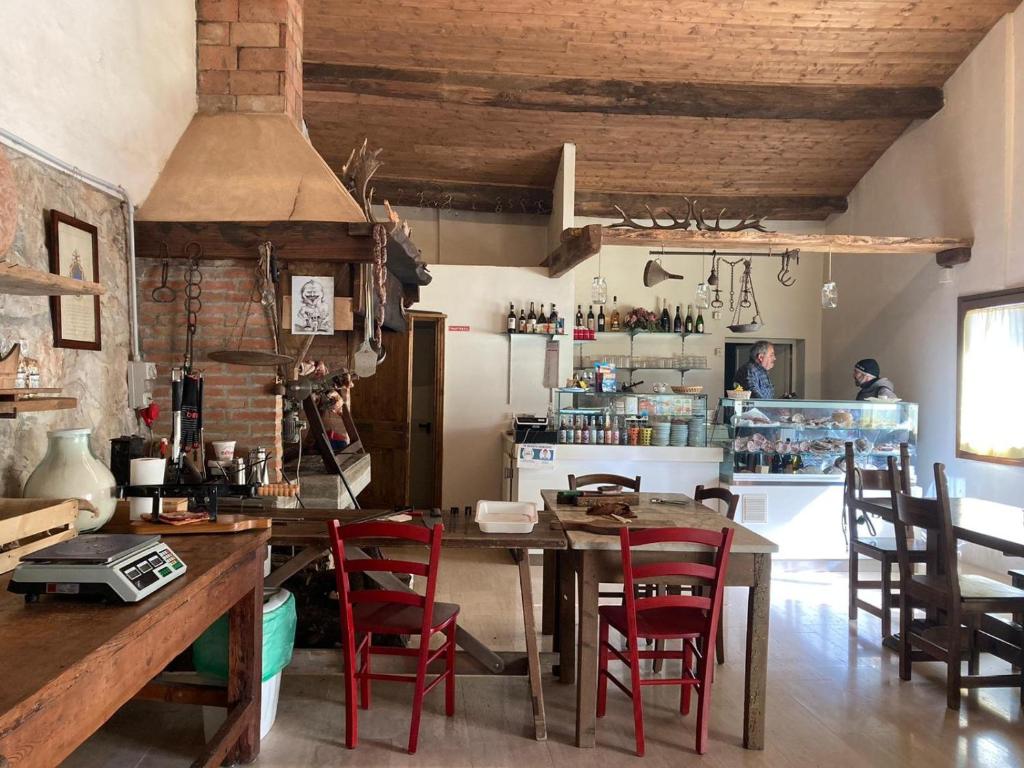 a kitchen with a wooden table and red chairs at Agriturismo Poggio alla Luna in Gerfalco