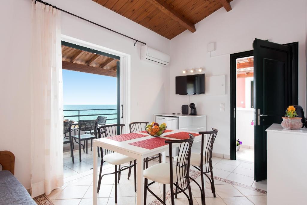 een keuken en eetkamer met een tafel en stoelen bij Corfu Anemoessa Apt in Glyfada