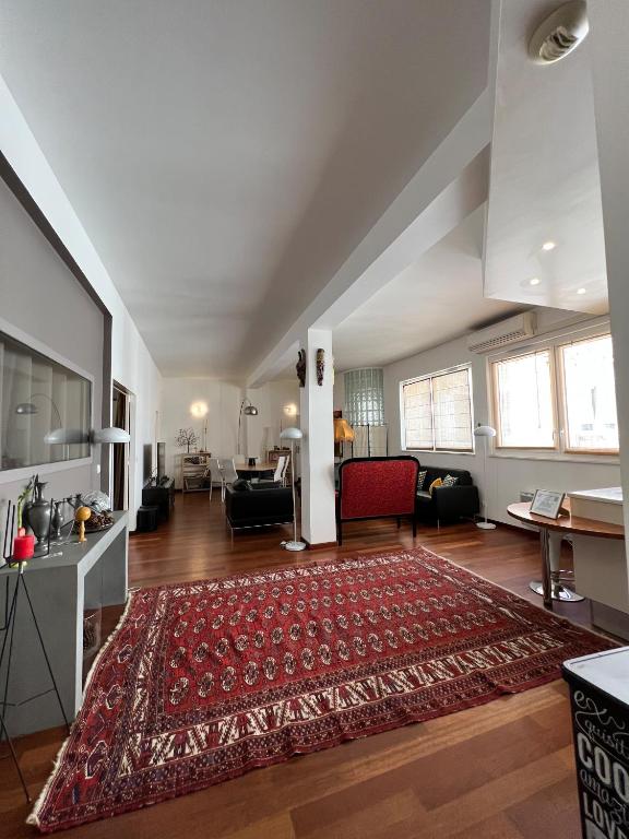 - un salon avec un tapis rouge au sol dans l'établissement Le Central Victoria III - Central Point - 105m2, à Nancy