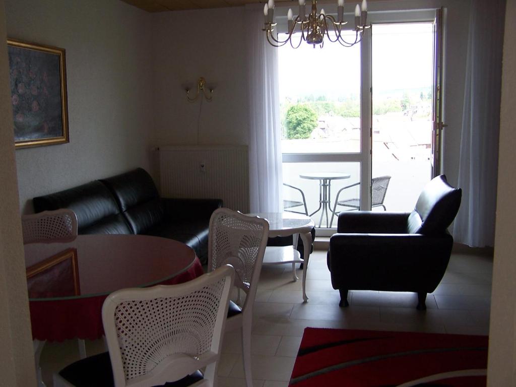 un soggiorno con divano, tavolo e sedie di Apartment Ilmtal Jena a Bad Berka