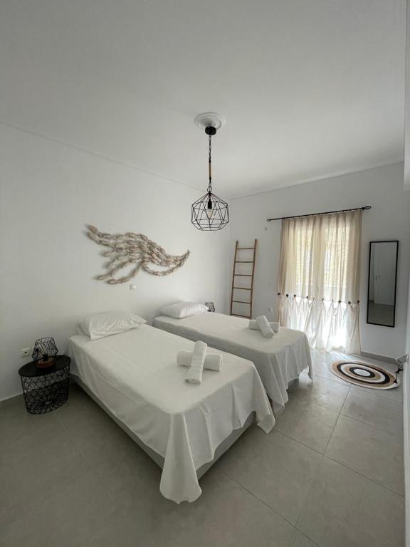 a bedroom with two beds and a chandelier at Lovely 2-bedroom apartment in the heart of Ermioni in Ermioni