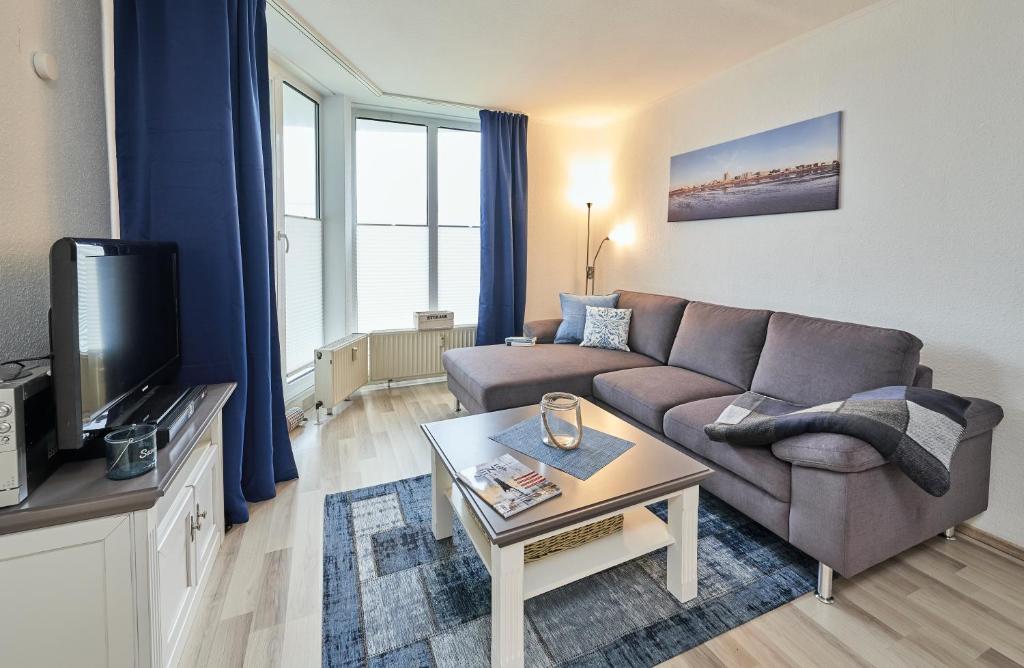 uma sala de estar com um sofá e uma televisão em Hohe Worth - 211 em Cuxhaven