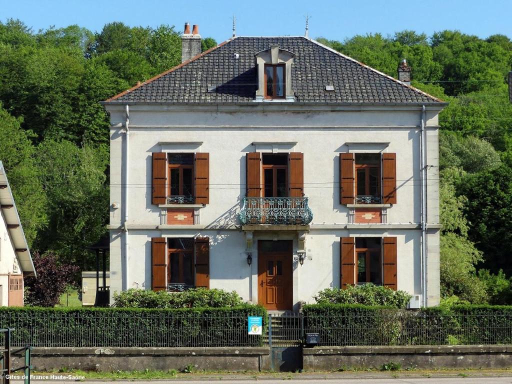 Casa blanca antigua con ventanas y balcón en Au Fil du Temps, en Fougerolles