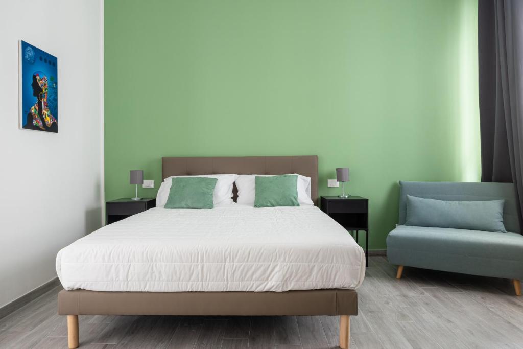 sypialnia z łóżkiem i niebieskim krzesłem w obiekcie Le Cinque Stanze Palermo Room&Breakfast w mieście Palermo
