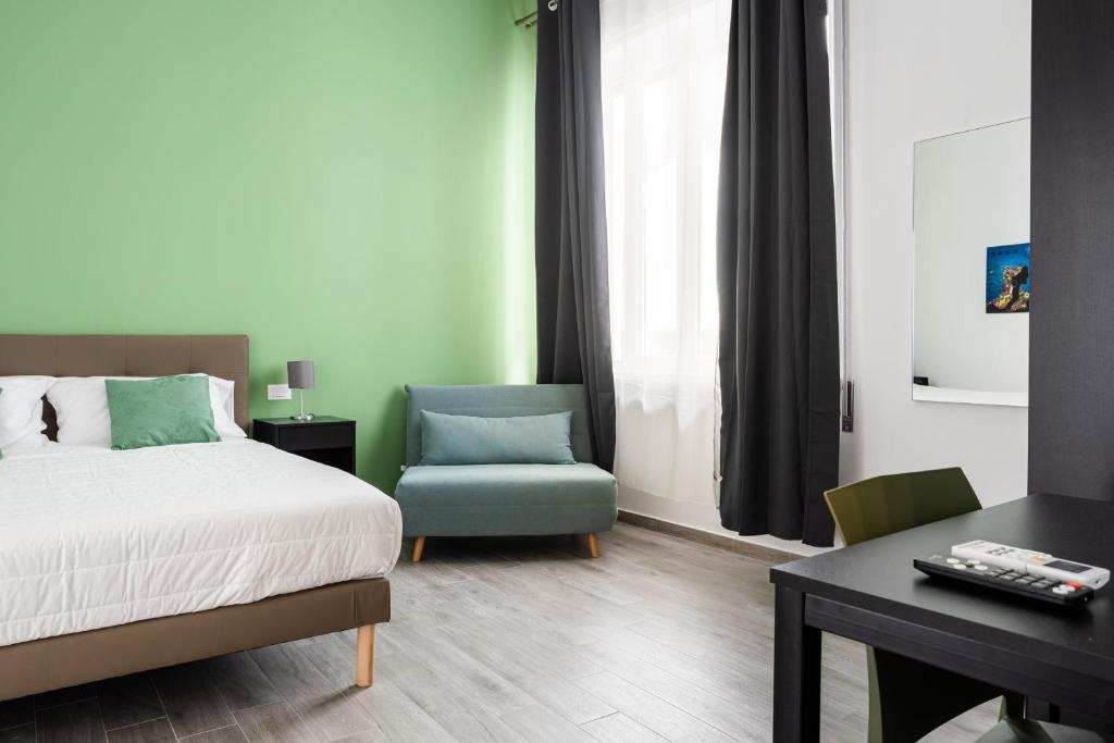 sypialnia z łóżkiem, krzesłem i biurkiem w obiekcie Le Cinque Stanze Palermo Room&Breakfast w mieście Palermo