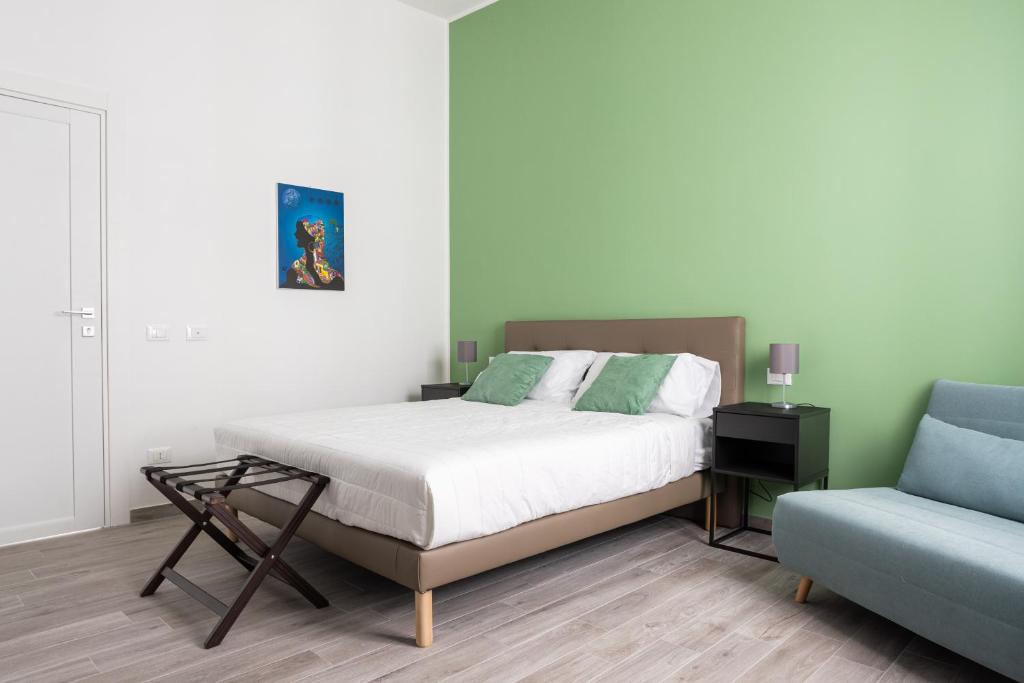 una camera con un letto e un divano blu di Le Cinque Stanze Palermo Room&Breakfast a Palermo