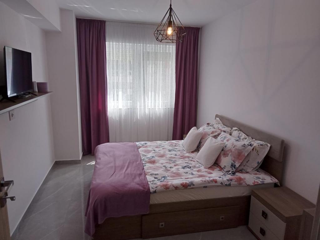 1 dormitorio con cama con almohadas y ventana en Apartament Gabriella's Home, en Oradea